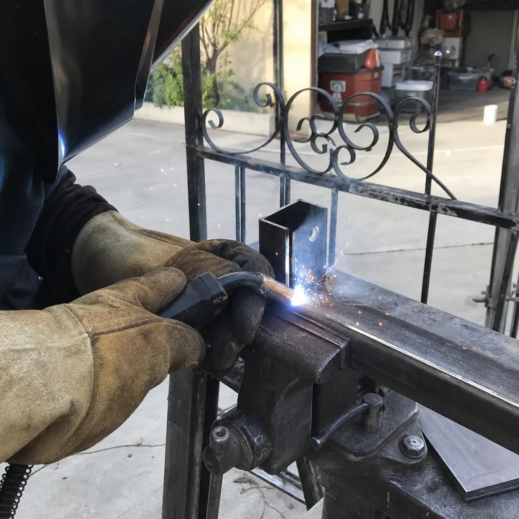 Professional welder performing custom gate parts repair and metal fabrication nationwide